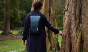 Frau mit grauem Basic LiWAVE Rucksack auf dem Rücken in der Natur