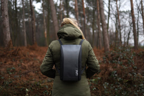 Frau mit grauem Basic LiWAVE Rucksack auf dem Rücken in der Natur