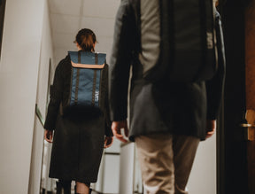 Frau und Mann mit LiWAVE Rucksack auf dem Rücken im Hotel